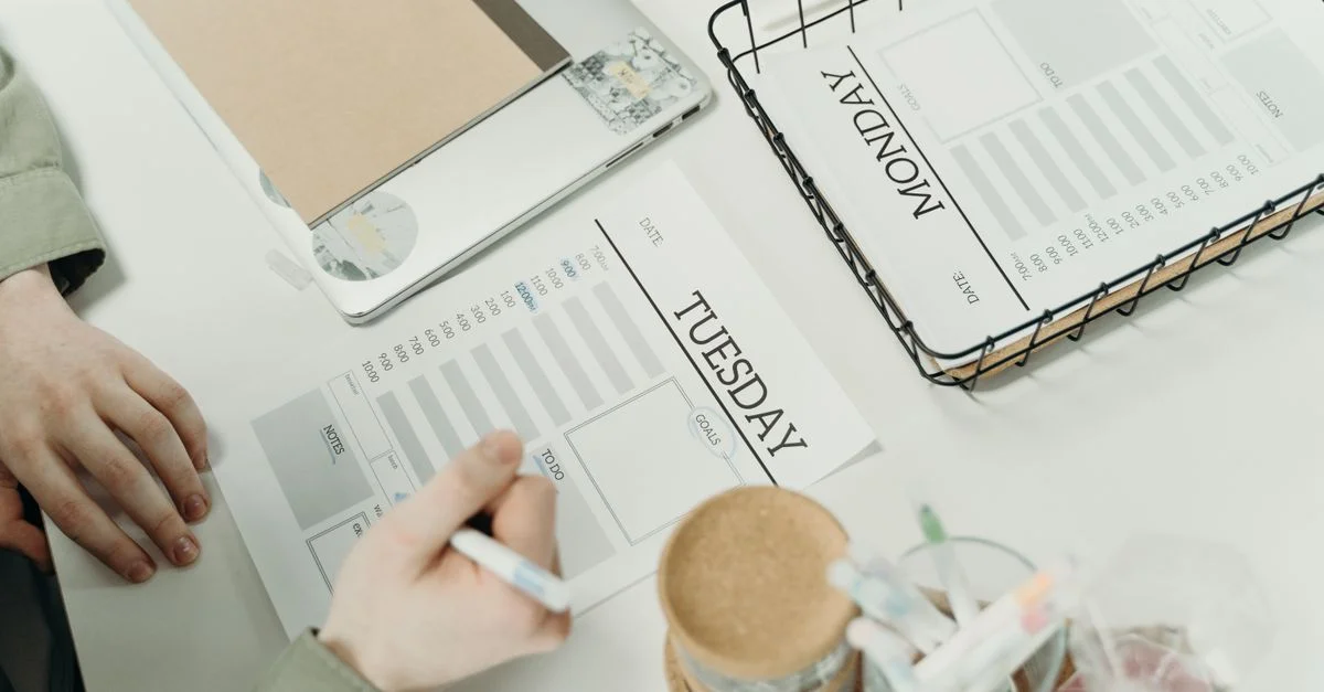 Un professionnel organisant la semaine avec des planificateurs de calendrier détaillés dans un bureau.