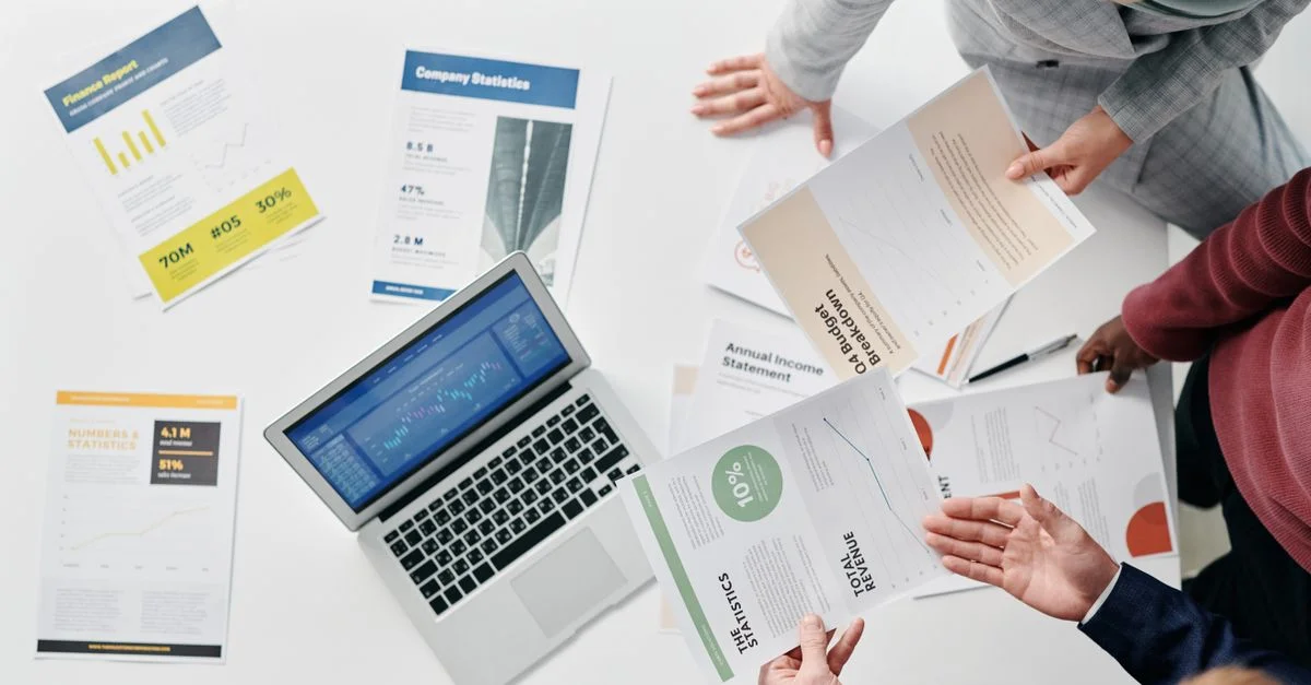 Vue de dessus d'une réunion professionnelle de bureau avec des documents et un ordinateur portable sur la table.